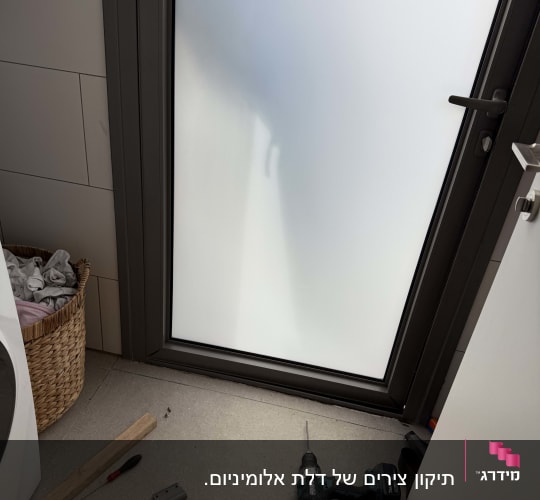 כלים ודלת אלומיניום בתהליך עבודה.